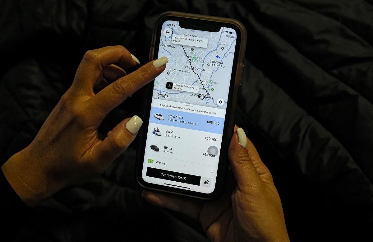 A woman checks the Uber transport application on her mobile phone after authorities ordered its suspension in Colombia. Photo/AFP