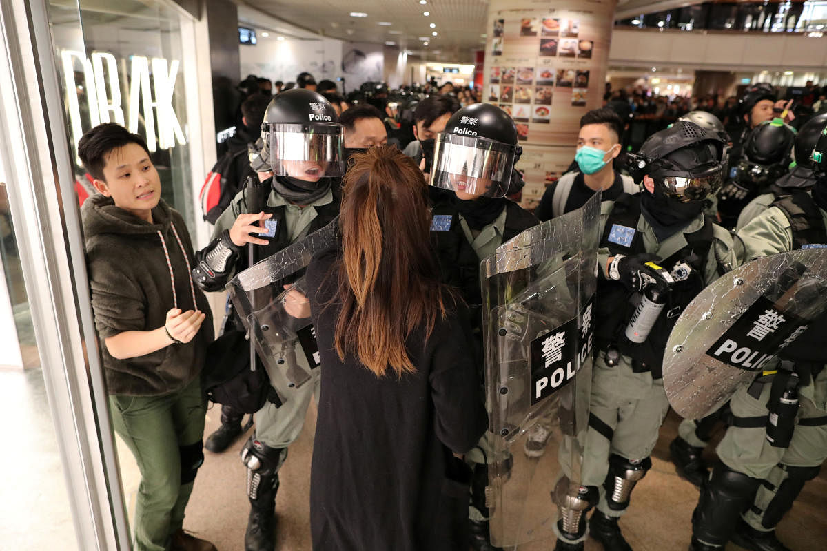 Riot police push back a shopper as Hong Kong protesters march in Harbour City shopping mall in Hong Kong, China. (Reuters Photo)