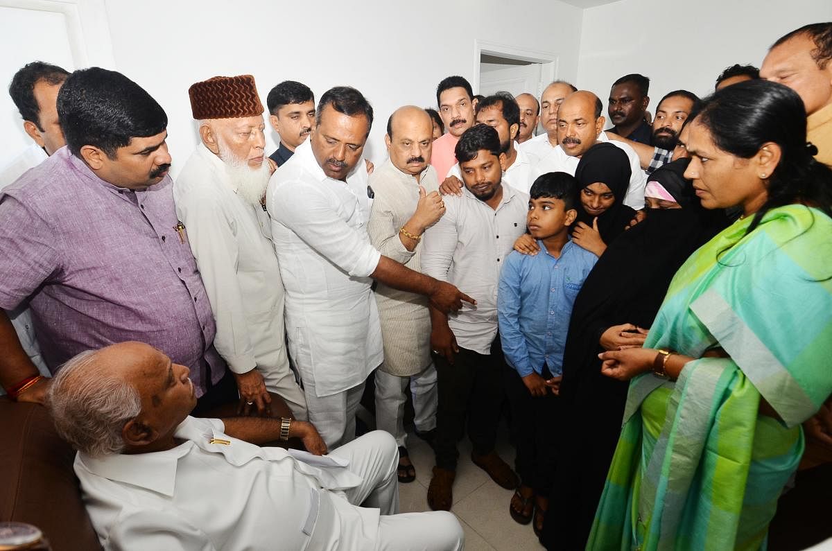 Chief Minister B S Yediyurappa interacts with the families of people who died in the police firing at Circuit House, Mangaluru, on Saturday.