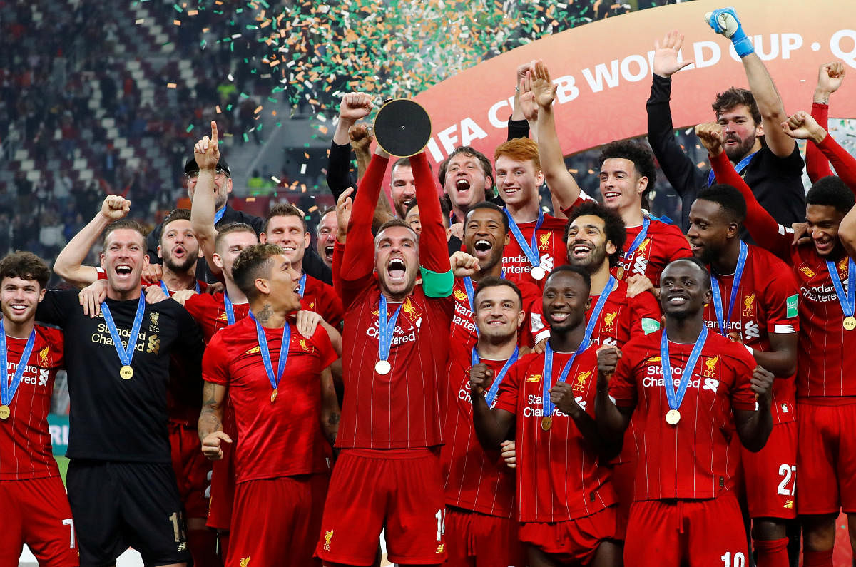 Liverpool's Jordan Henderson lifts the trophy as they celebrate after winning the Club World Cup. (Reuters Photo)