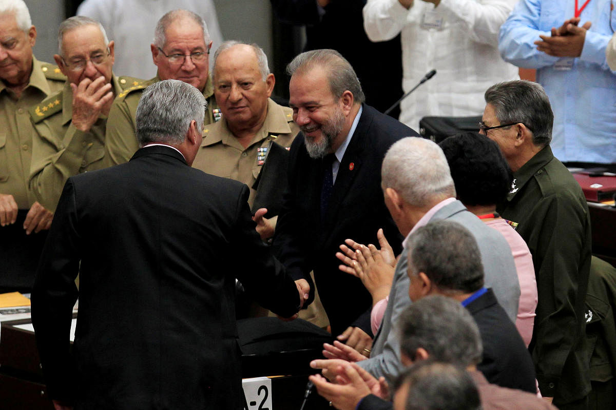 Cuban President Miguel Diaz-Canel and Tourism Minister Manuel Marrero Cruz, named as the country's first prime minister, a role created by the new constitution, shake hands during the ordinary session of the National Assembly in Havana, Cuba, December 21,