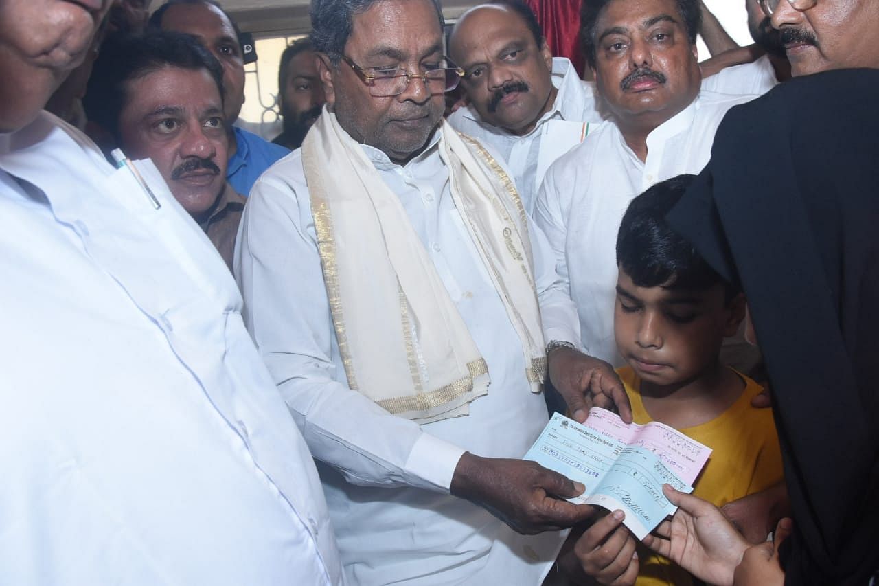  Chief Minister Siddaramaiah handed over cheques for Rs 7.50 lakh each to the family of victims of police firing (DH Photo)