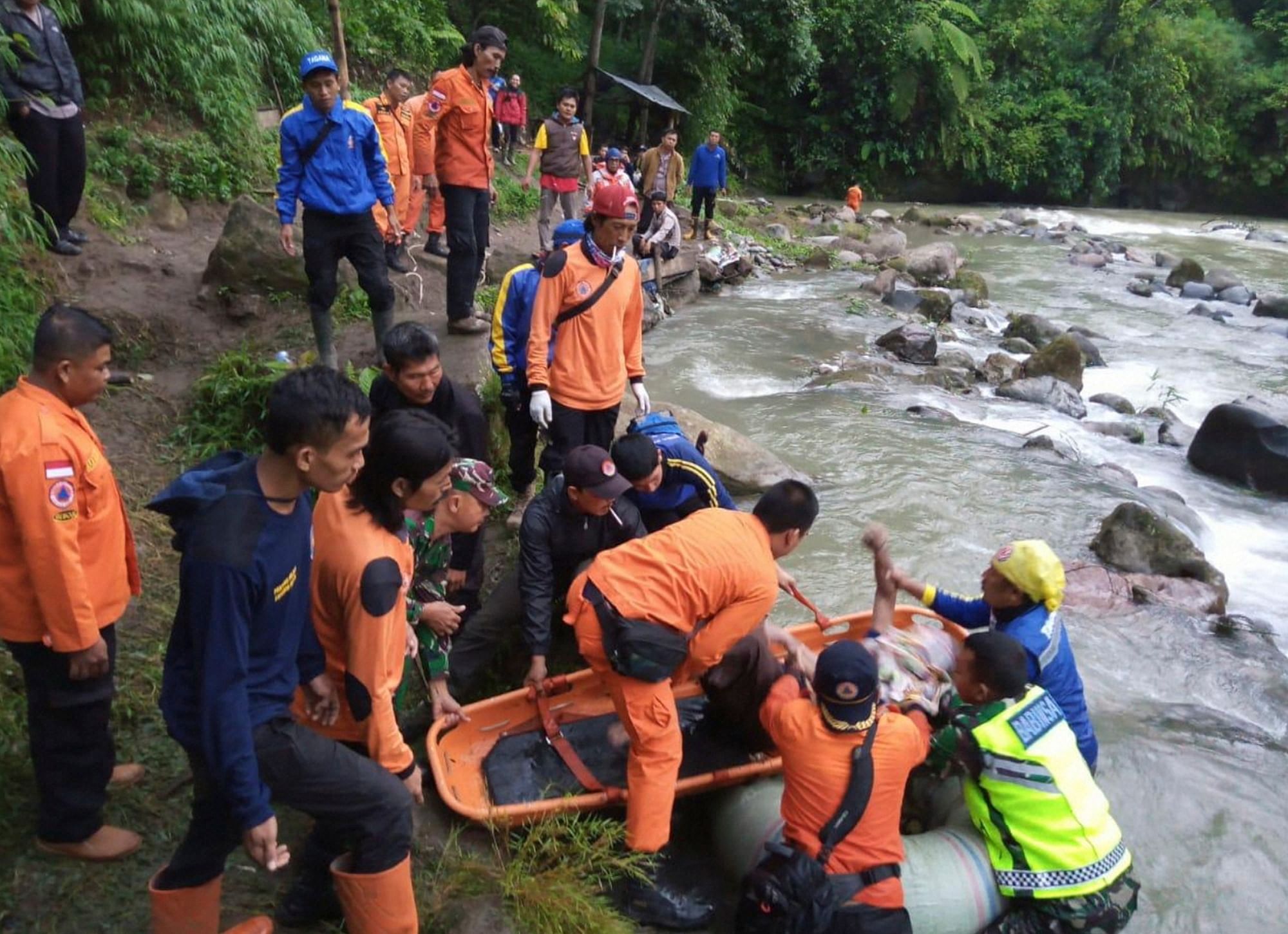  In this photo released by the National Search And Rescue Agency (BASARNAS), rescuers remove the body of a victim of a bus accident in Pagaralam, Indonesia, Tuesday, Dec. 24, 2019.(AP Photo)
