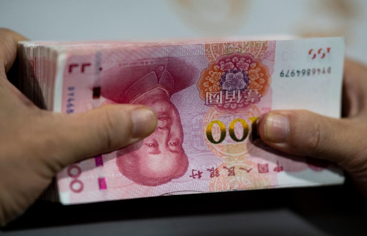 A bank employee counting out 100 yuan (14.6 USD) notes at a bank in Shanghai. (AFP Photo)