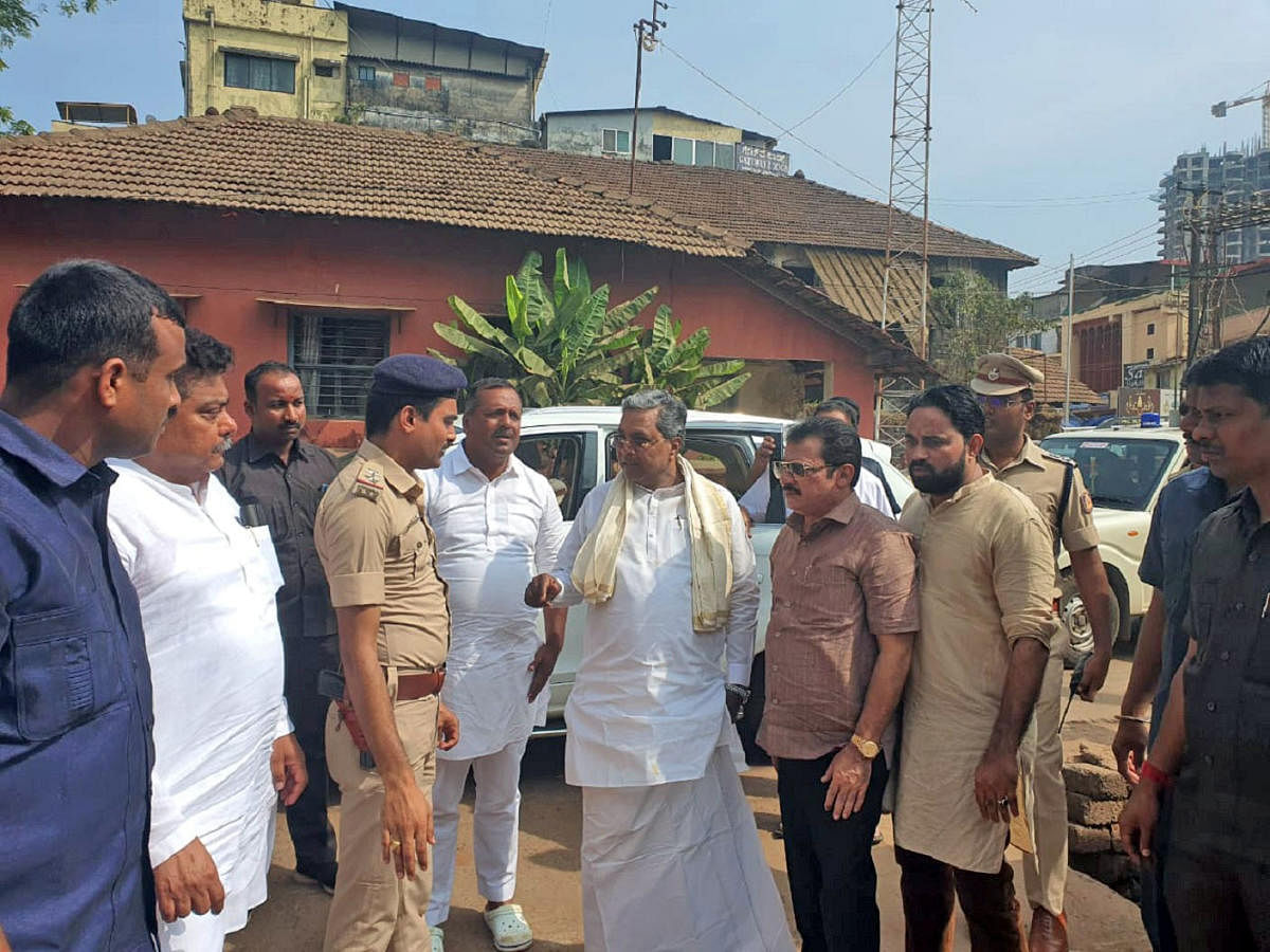 Former chief minister Siddaramaiah collects information from police on firing, near Bunder Police Station, in Mangaluru on Monday.