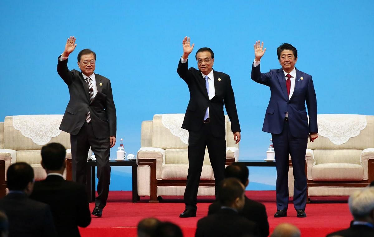 South Korea's President Moon Jae-in, Chinese Premier Li Keqiang and Japanese Prime Minister Shinzo Abe wave at the beginning of the trilateral business meeting between China, South Korea and Japan in Chengdu, southwestern China's Sichuan province on December 24, 2019. (AFP Photo)
