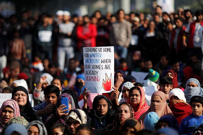 A girl holds a placard as she attends a protest against a new citizenship law, outside the Jamia Millia Islamia university in New Delhi. (Reuters Photo)