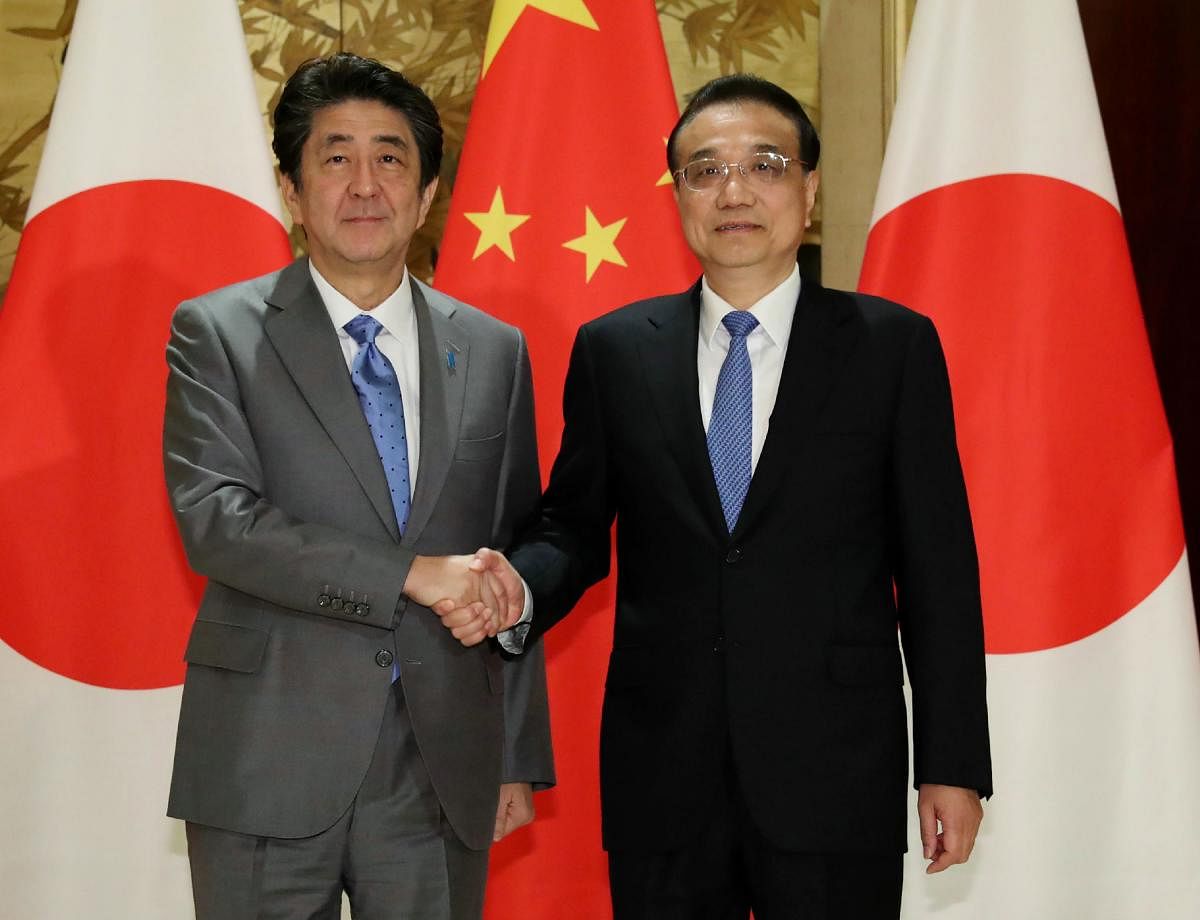 China's Premier Li Keqiang (R) shakes hands with Japan's Prime Minister Shinzo Abe. (AFP Photo)