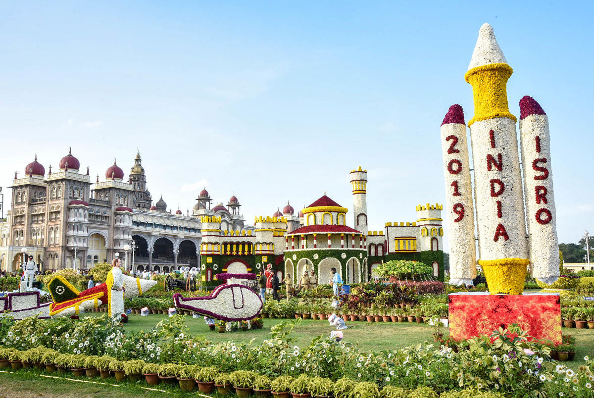 A replica of satellite launch and the Bengaluru palace replice with Mysuru Palace in the background at the flower show. DH PHOTOS/Savitha B R