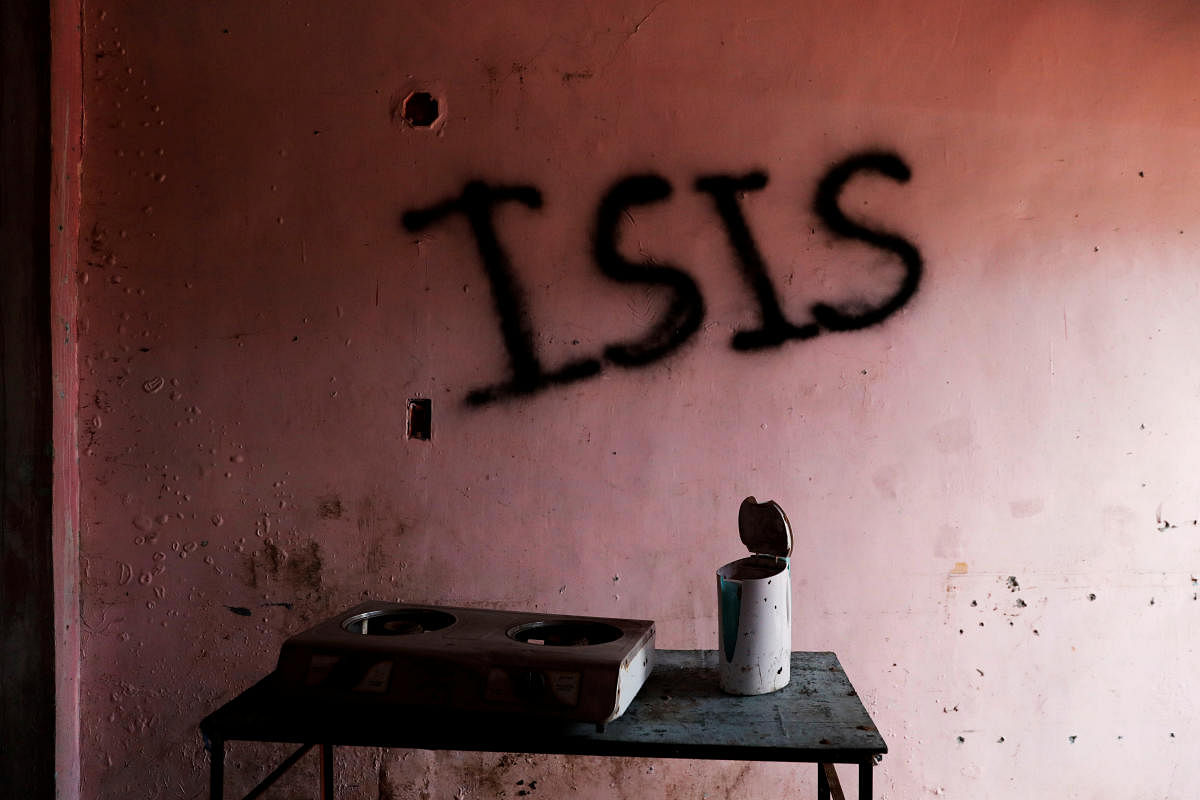 Burnt kitchen items are seen in front of a wall spray-painted with the word "ISIS" in a home in the most affected war-torn area of Marawi City. (Reuters Photo)