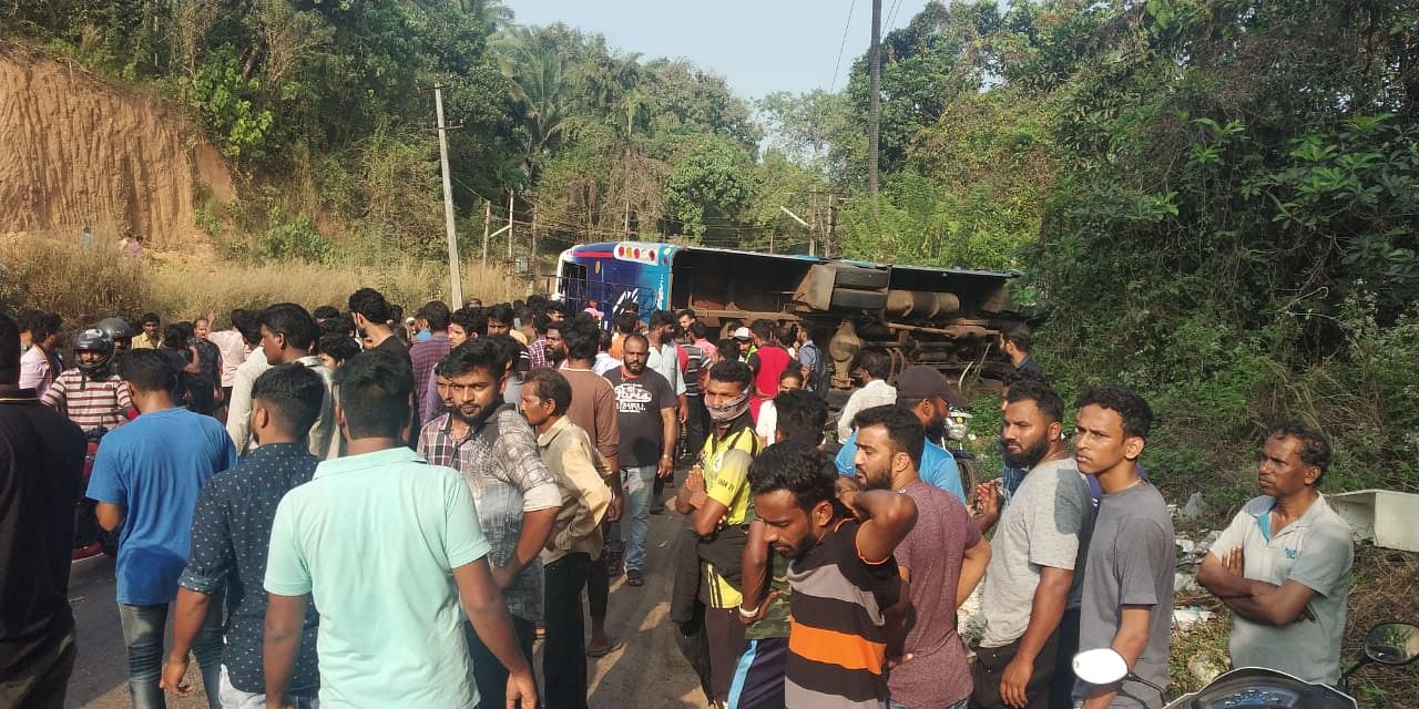 The crowd around the bus that rolled on its side after colliding with a car in Parari near Vamanjoor on city's outskirts on Saturday. The mangled vehicle. (DH Photo)