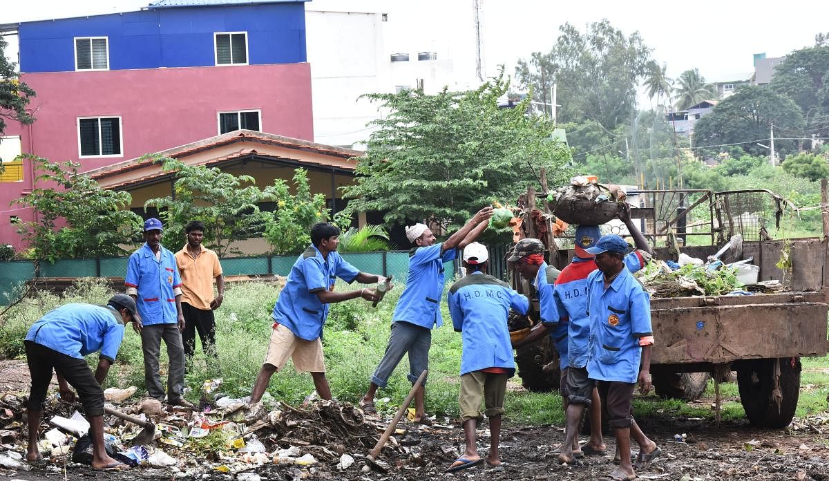 Civic workers cleaning the street in Hubballi-Dharwad City.