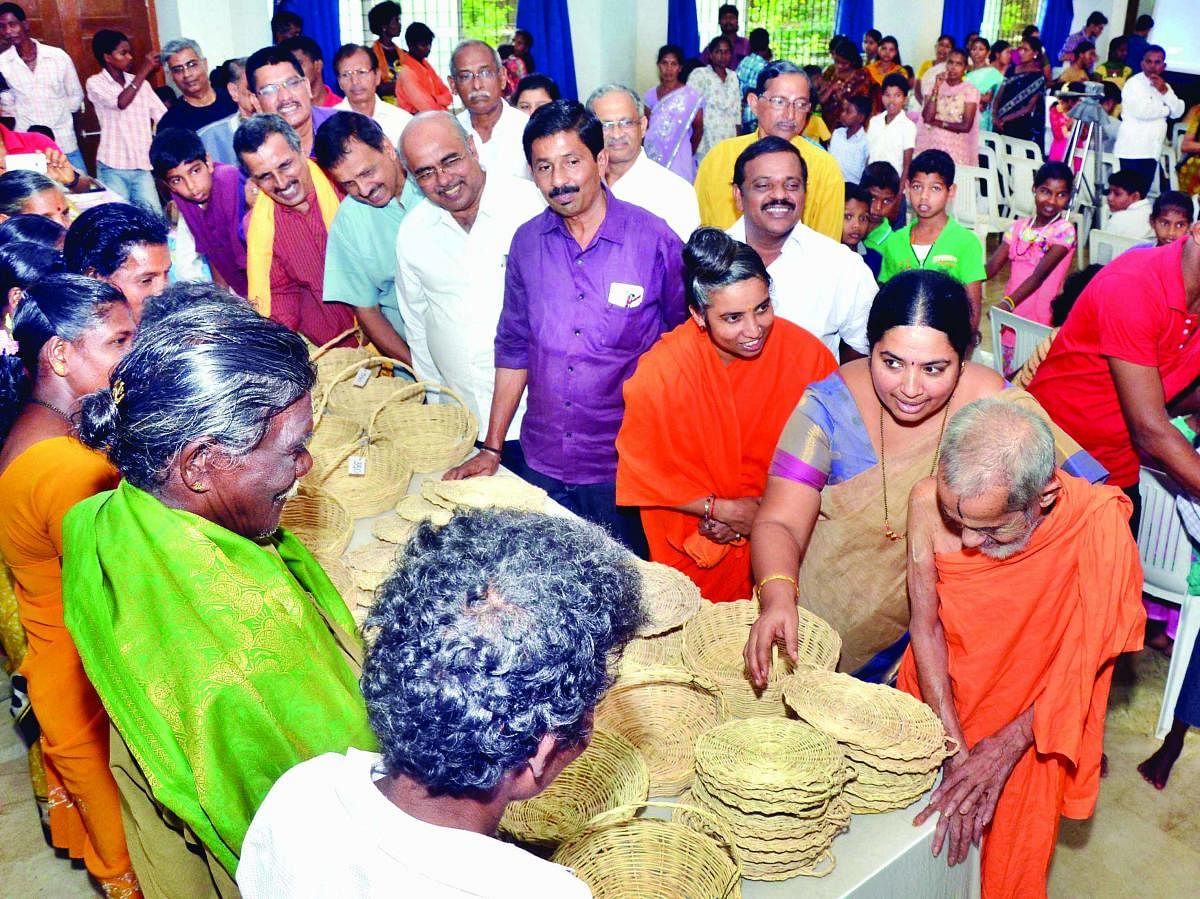 Pejawar seer inspects the baskets made by members of Koraga community. DH File Photo