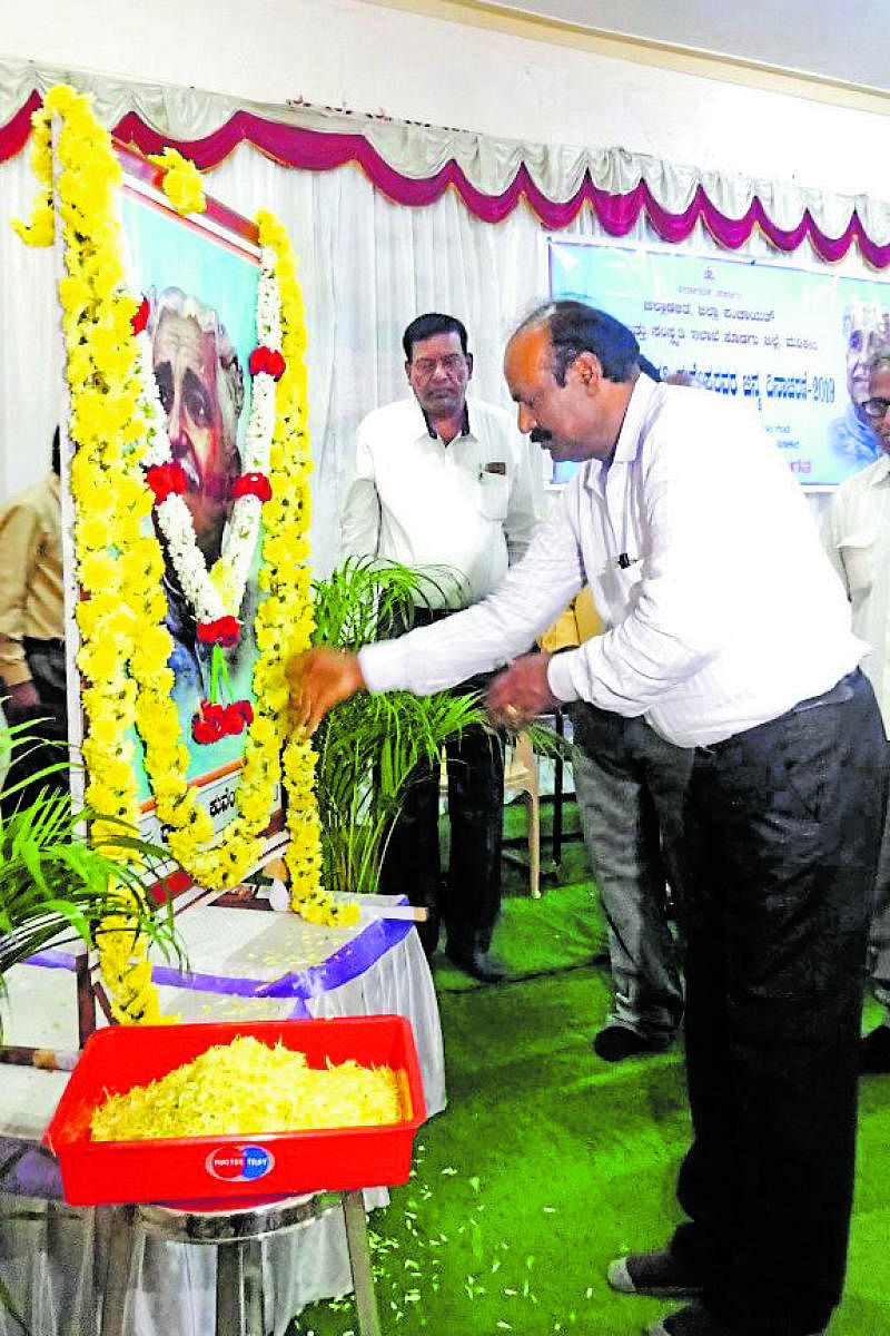 District Kannada Sahitya Parishat President B S Lokesh Sagar pays floral tributes to a portrait of Kuvempu on the occasion of Rastrakavi Kuvempu birth anniversary at D Devraj Urs Bhavana in Madikeri on Sunday.