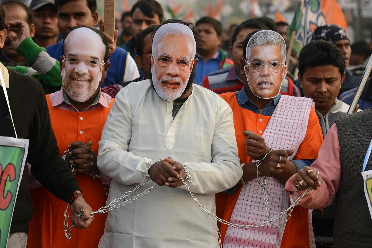 Supporters and activists of the Trinamool Congress (TMC) take part in a rally against India's new citizenship law chained up and wearing masks of Indian Prime Minister Narendra Modi (C), Home Minister Amit Shah (L) and West Bengal BJP president Dilip Ghosh, in Siliguri on December 28, 2019. Photo/AFP