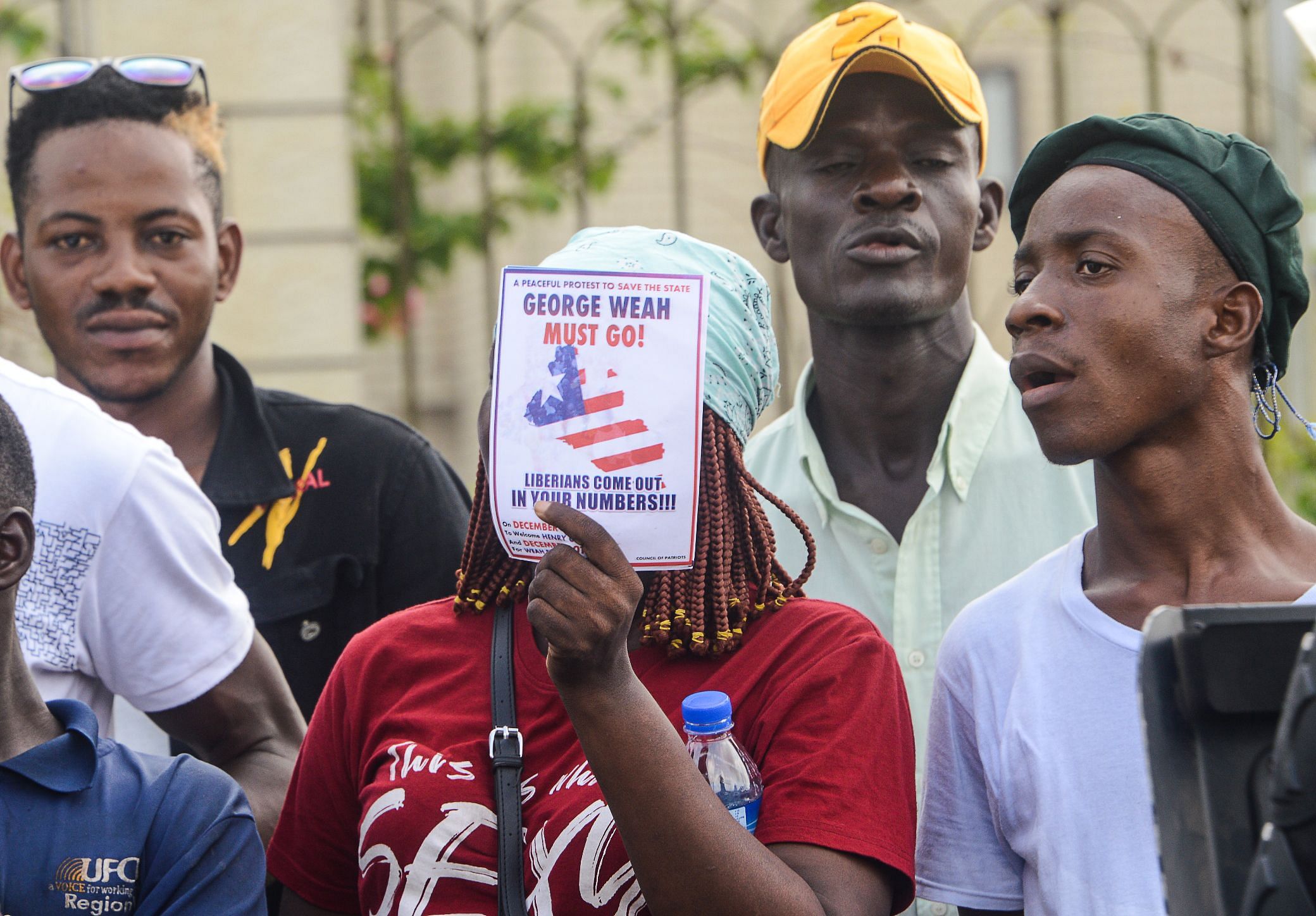 A supporters of Liberian radio show host and opposition leader Henry Costa holds an anti-Liberian President Geroge Weah flier during Costa's arrival in after landing in Monrovia. (AFP Photo)