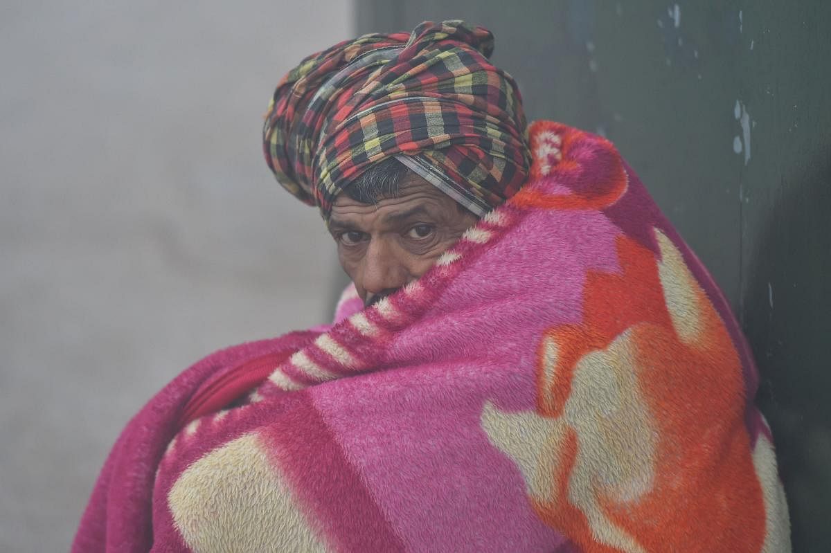 A man wraps a blanket to protect himself from cold wave conditions during a foggy morning in New Delhi, Monday, Dec 30,2019. (PTI Photo)