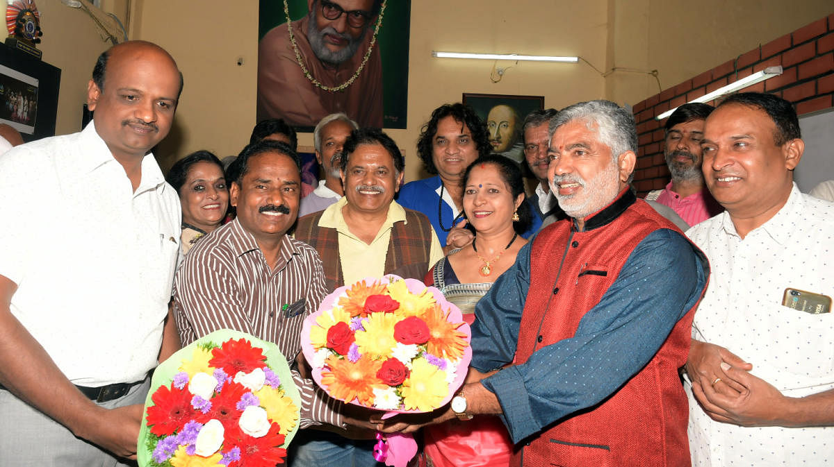 Rangayana Joint Director V N Mallikarjuna Swamy welcomes new Director Addanda Cariappa in Mysuru, on Tuesday. Kannada and Culture Assistant Director H Chennappa, and theatre person Anitha Cariappa are seen. dh photo