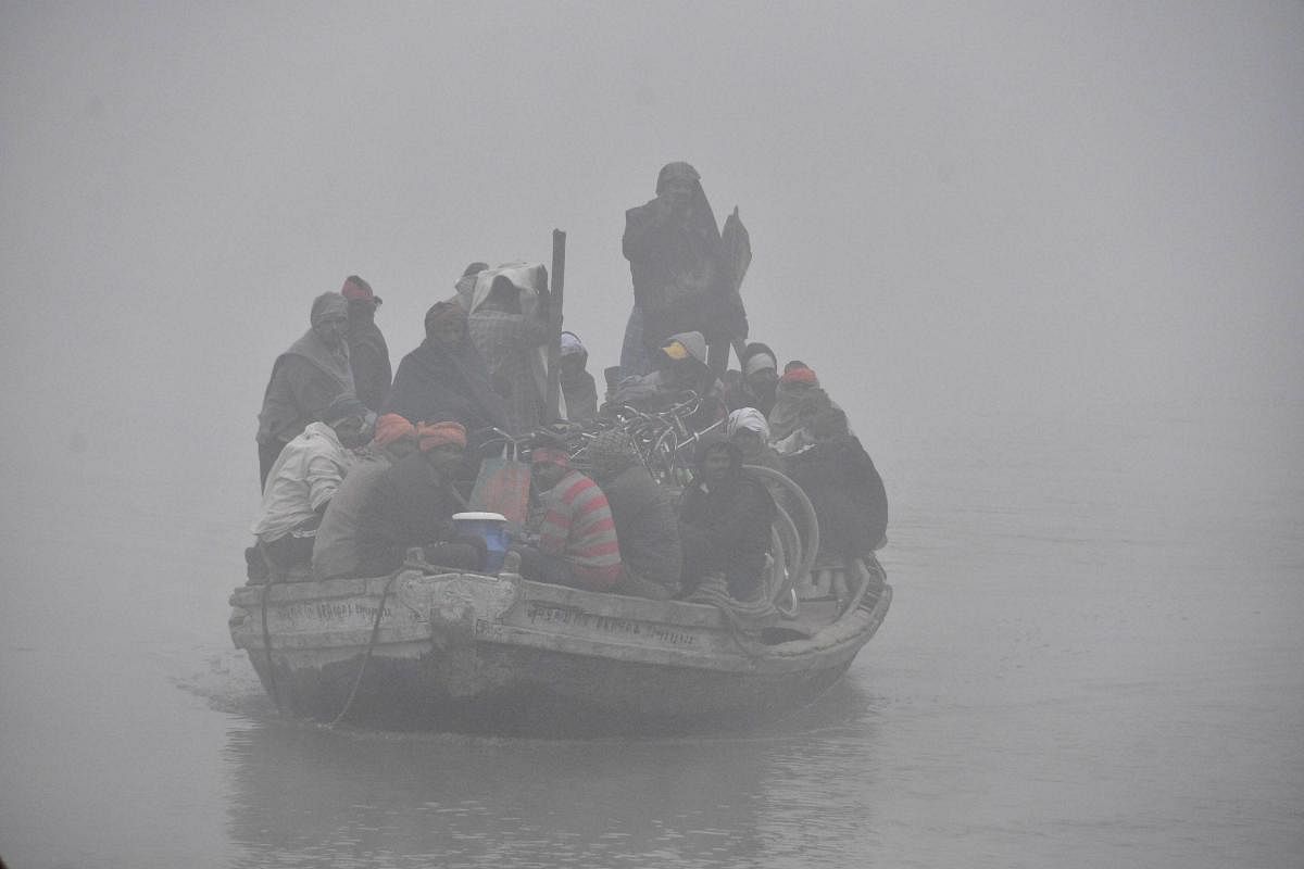  A boat overloaded with passengers and bicycles crosses the River Ganga on a cold and foggy morning in Patna. PTI
