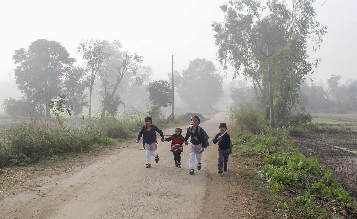 Children on their way to school during a cold and foggy morning, on the outskirts of Jammu, Monday, Dec. 16, 2019. (PTI Photo)