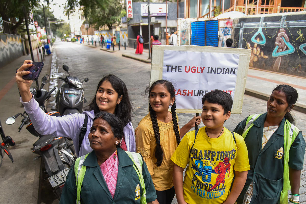 Civic volunteers and pourakarmikas pose on a clean Church Street on Wednesday. DH PHOTO