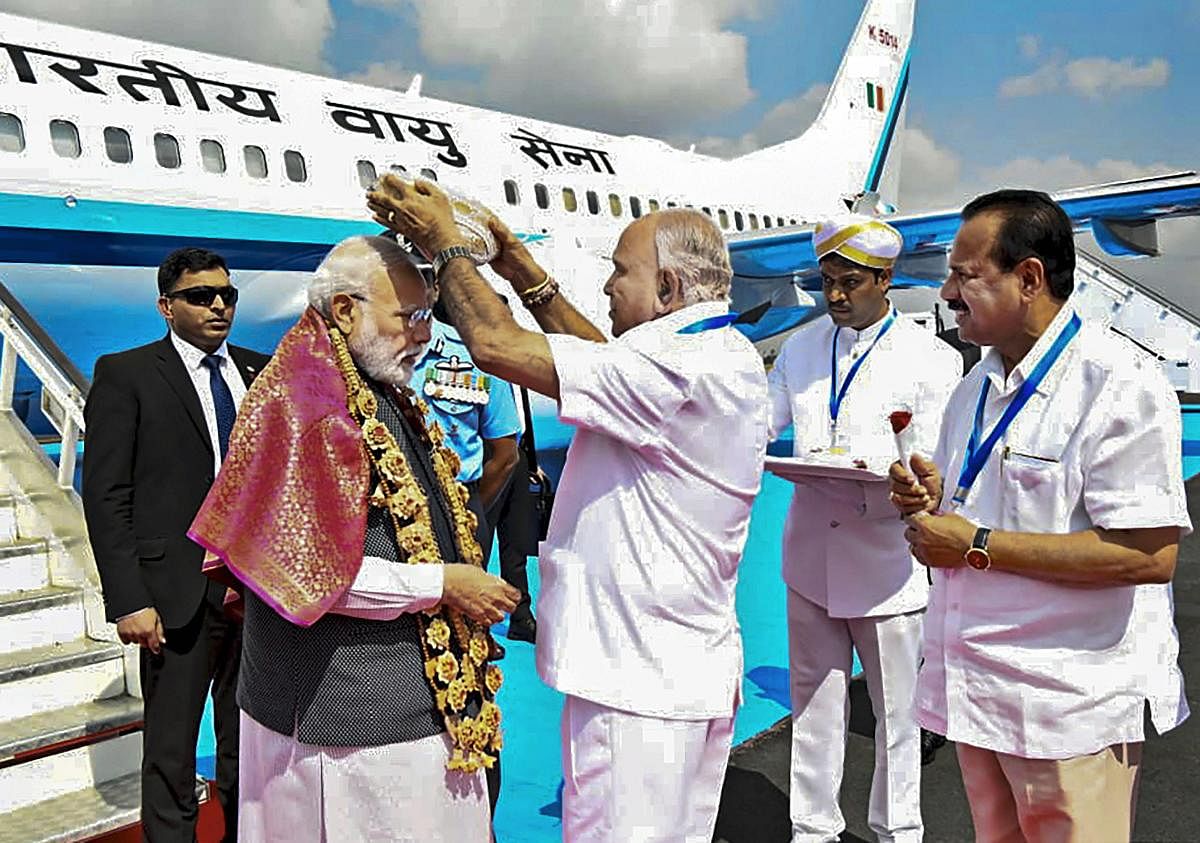 Prime Minister Narendra Modi being greeted by Karnataka Chief Minister BS Yediyurappa, as Union Minister for chemicals and fertilizers Sadananda Gowda looks on, upon his arrival at a airport in Bengaluru, Thursday, Jan. 2, 2020. Modi is on a 2-day visit to Bengaluru. (PTI Photo)