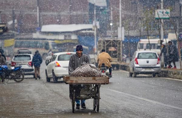 A vendor pushes his cart during light snowfall in Srinagar, Friday, Dec. 20, 2019. (PTI Photo/S. Irfan)