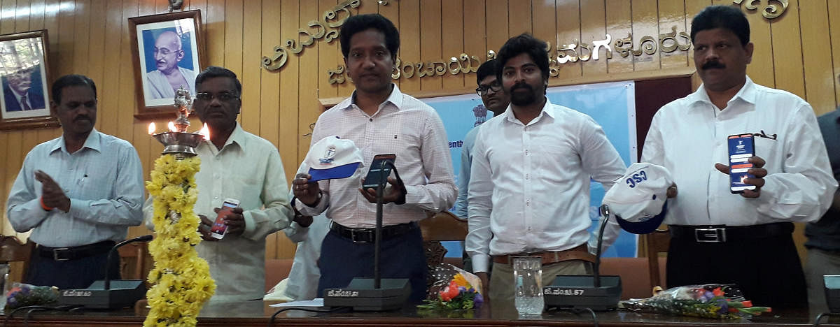 Deputy Commissioner Dr Bagadi Gautham displays a mobile app used for the economic census in Chikkamagaluru.