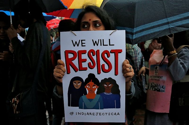 A demonstrator displays a placard as she attends a protest rally against a new citizenship law, in Kolkata. (Reuters Photo)