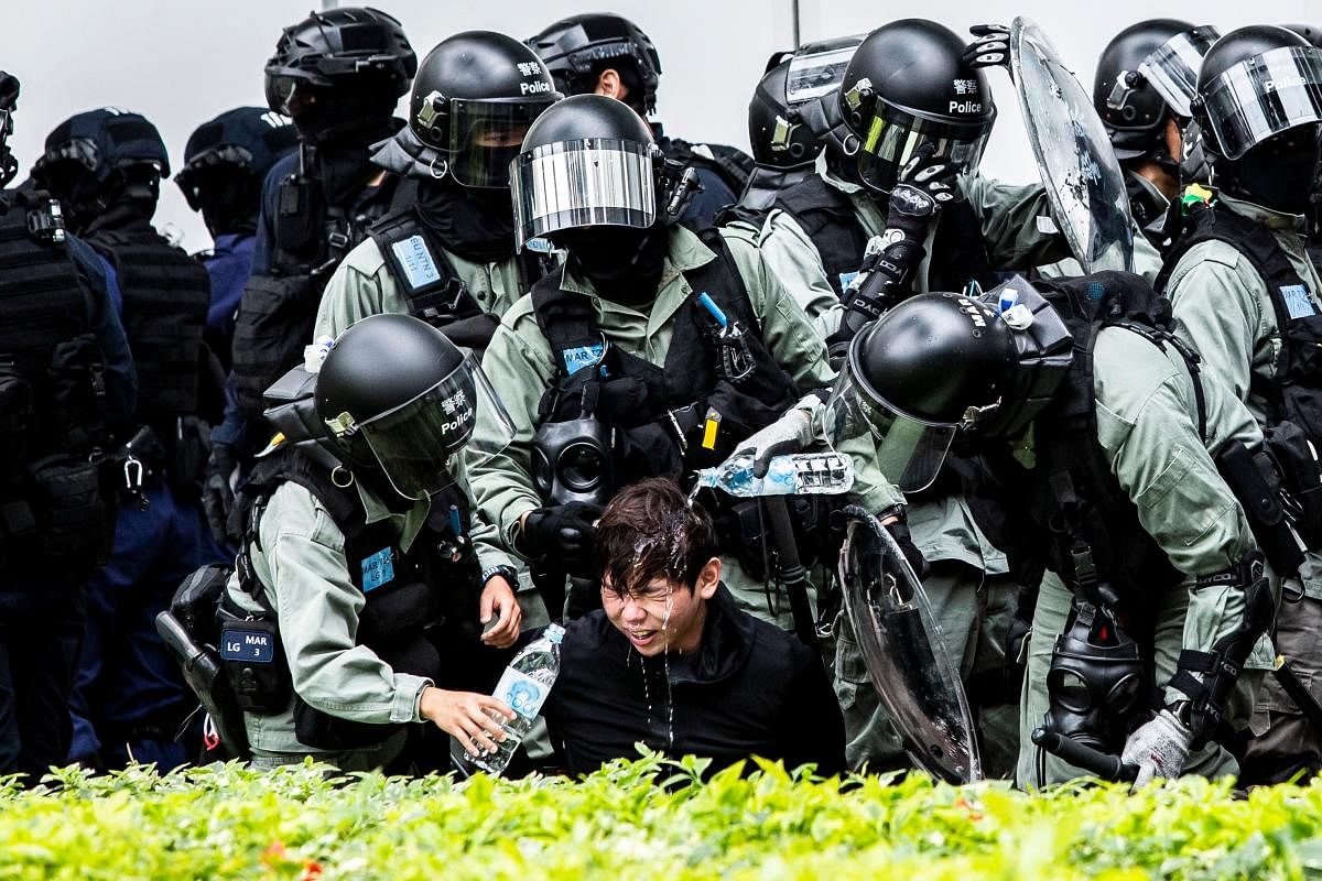 A man (C) has pepper spray washed from his his face by police after being detained during a clearance operation after a demonstration against parallel trading in Sheung Shui in Hong Kong on January 5, 2020. (AFP photo)