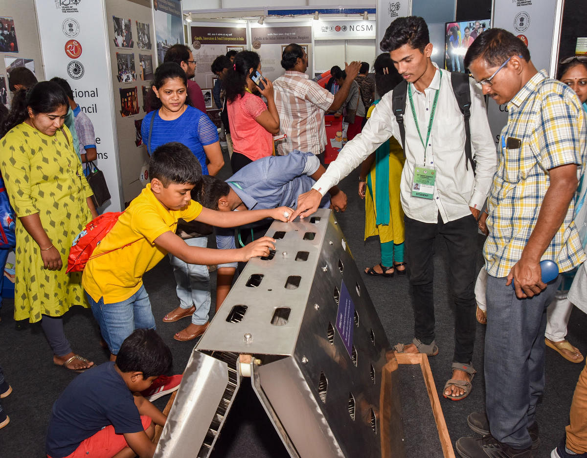 Vistors look at a science model at the expo held as part of 107th Indian Science Congress on the GKVK premises in Bengaluru on Sunday. DH PHOTO