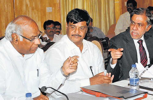 Chief Secretary S V Ranganath (right) shares a word with Railway Minister Mallikarjuna Kharge at a meeting in Bangalore on Monday. PWD Minister Dr H C Mahadevappa  (centre) is with them. dh photo