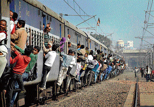 Passengers travel by an overcrowded local train in Patna on Wednesday. PTI