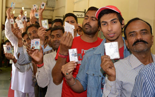 People wait in a queue to cast their votes for Lok Sabha election in Amritsar on Wednesday. PTI Photo
