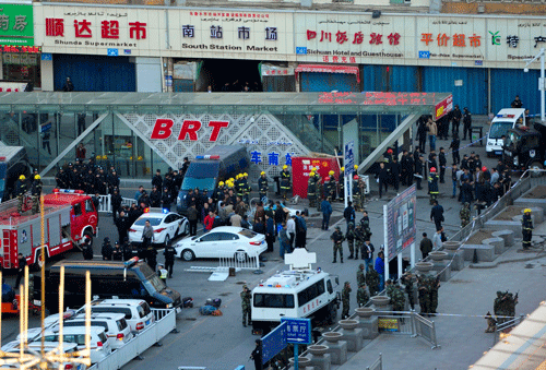 Security personnel gather near the scene of an explosion outside the Urumqi South Railway Station in Urumqi in northwest China's Xinjiang Uygur Autonomous Region on Wednesday April 30, 2014. An explosion shook the railway station in China's restive far-western region of Xinjiang, injuring many people as President Xi Jinping wrapped up a four-day visit to the area, state media said Wednesday. AP