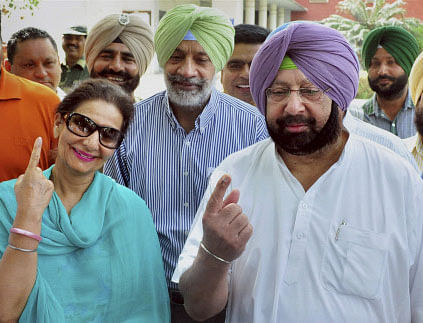 Former Punjab Chief Minister, Capt. Amrinder Singh and party candidate Preneet Kaur after casting votes for Patiala assembly bypoll, in Patiala . PTI photo