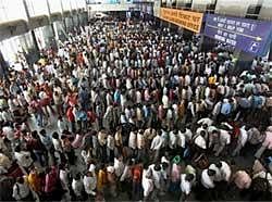 Passengers stand in queues to purchase tickets at various counters at New Delhi Railway Station on Monday, a day after two persons were killed in a stampede at the station. PTI