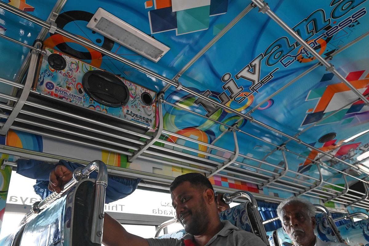 Passengers sit under a speaker in a private bus in Piliyandala, a suburb of Colombo on January 2, 2020. - Sri Lanka's government on January 2 gave bus operators two weeks to turn down the notoriously loud music in their vehicles following complaints from passengers. AFP