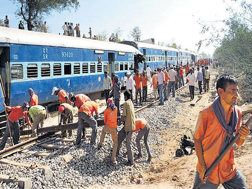 green signal: Workers clear the rail track on Saturday, a day after the Ernakulam-bound Intercity Express train derailed at Bidiregere near Anekal. dh Photo