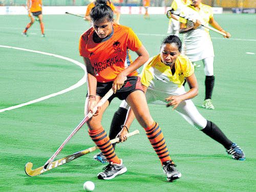 fine tussle Karnataka XI's Pooja MD (left) tries to get past Soundarya Yendala of the Central Railway. DH Photo