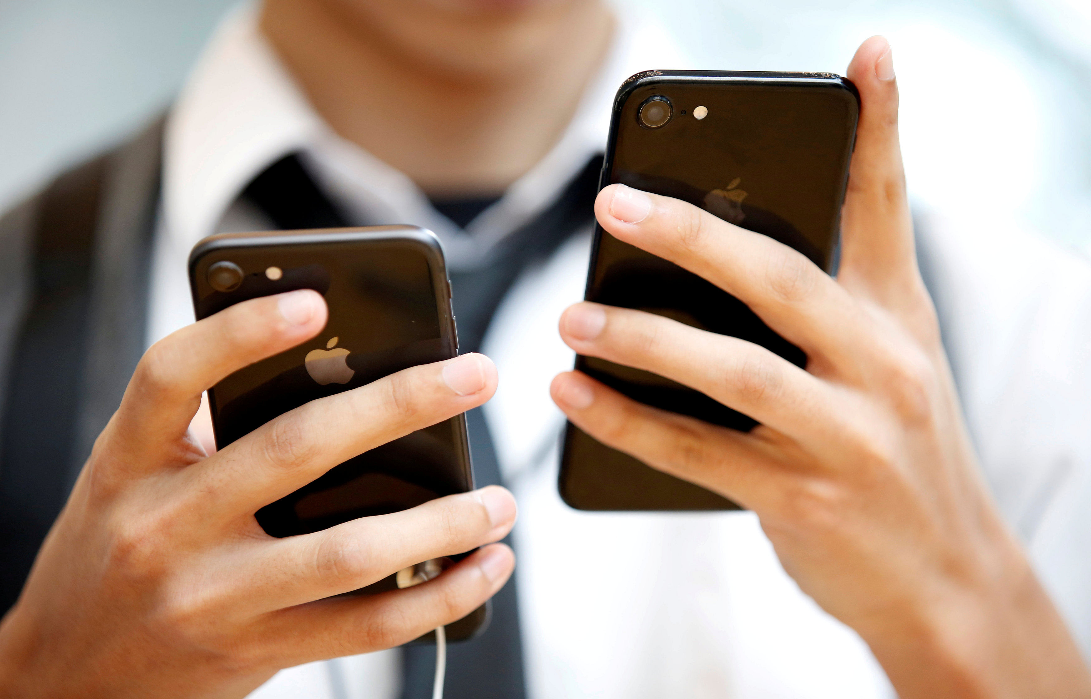 FILE PHOTO: A man looks at Apple's new iPhone 8 (L) and his iPhone 7 at the Apple Store in Tokyo's Omotesando shopping district (Reuters File Photo)