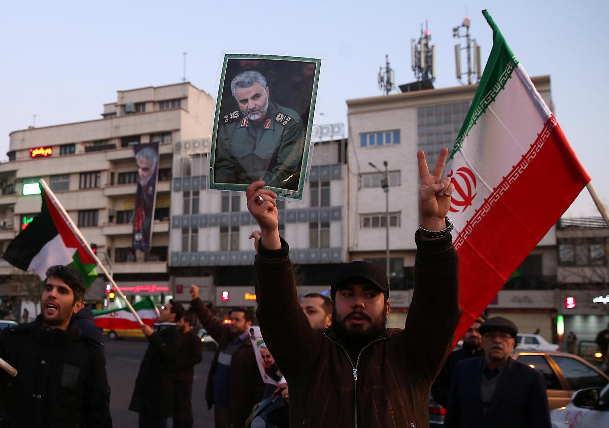 A man holds a picture of late Iranian Major-General Qassem Soleimani, as people celebrate in the street after Iran launched missiles at U.S.-led forces in Iraq. (Reuters Photo)