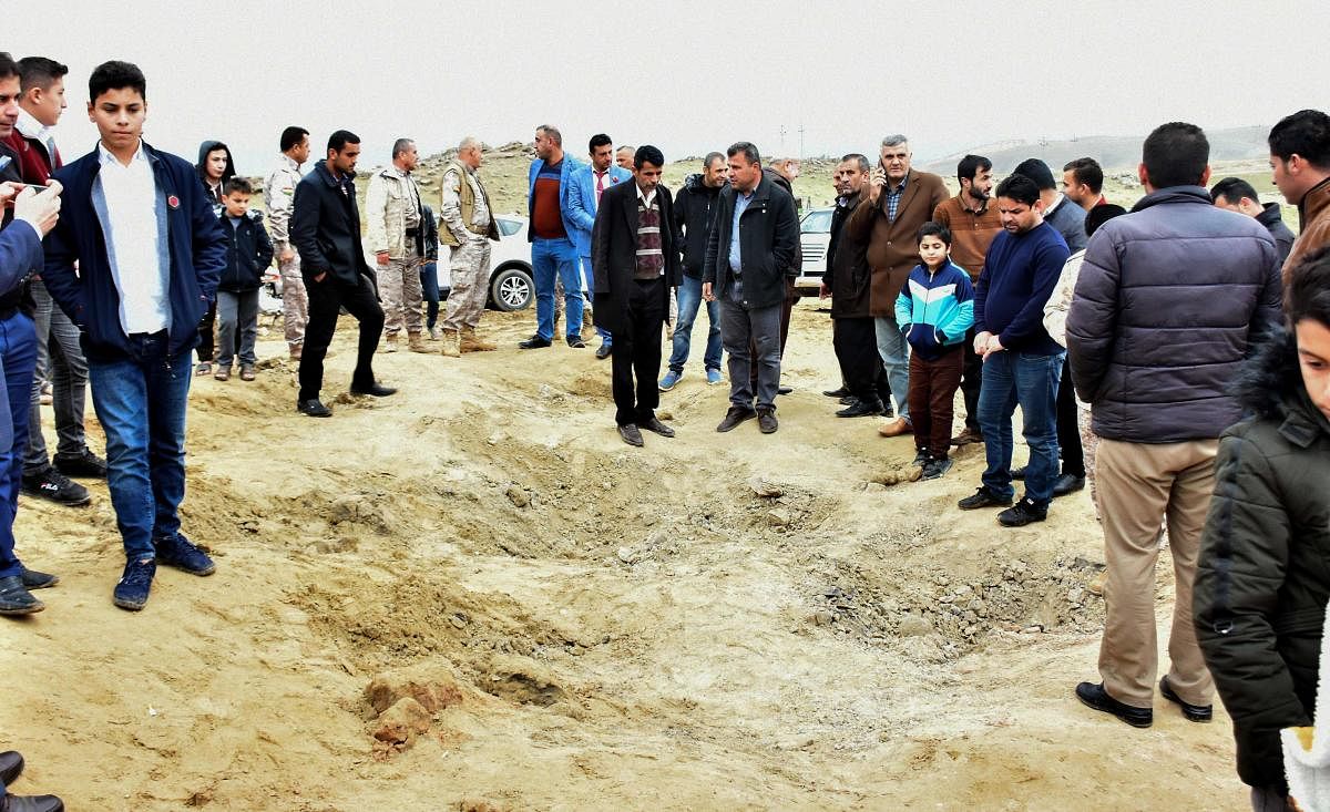 Iraqi Kurds inspect a crater caused by a reportedly Iranian missile initially fired at Iraqi bases housing US and other US-led coalition troops, in the Iraqi Kurdish town of Bardarash (AFP Photo)
