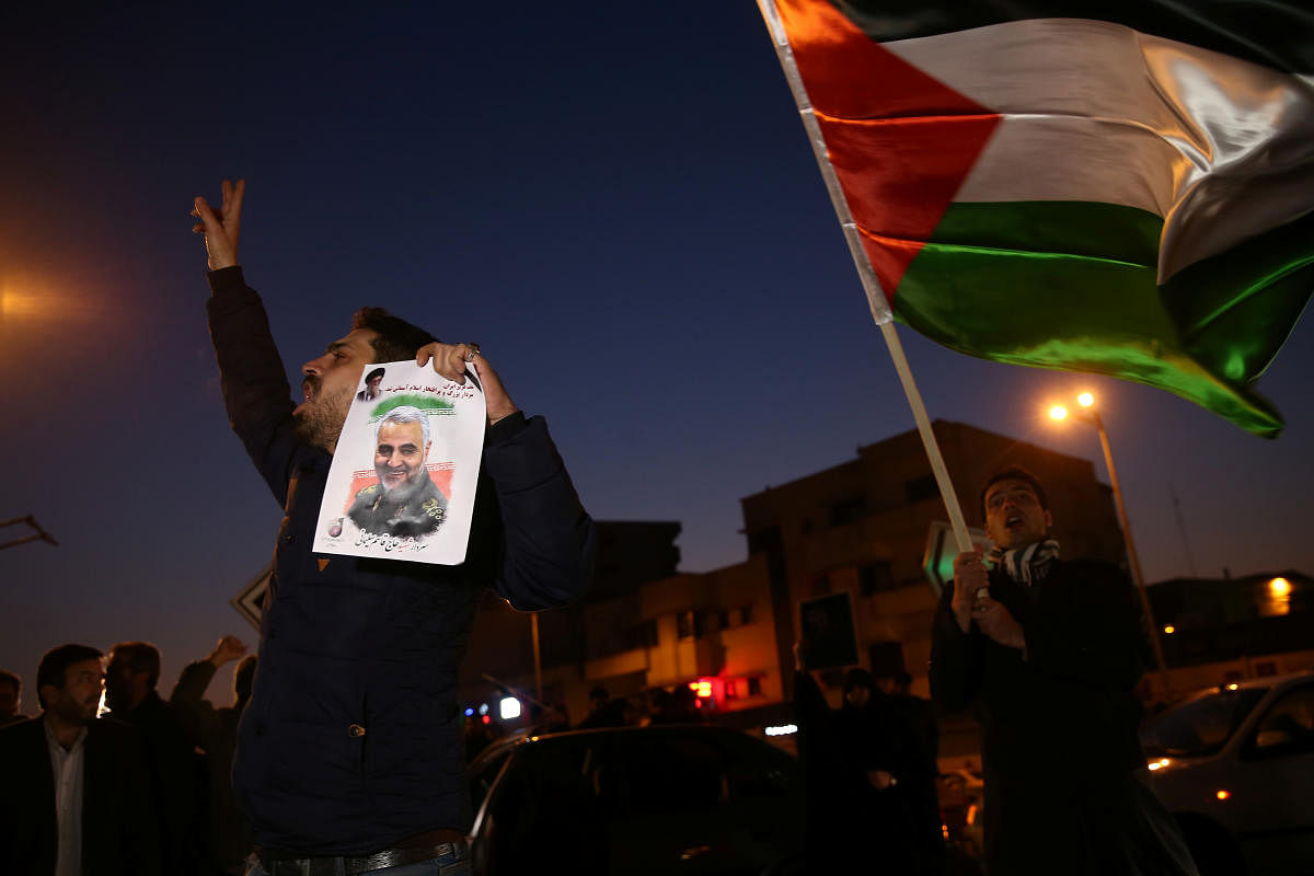A man holds a picture of late Iranian Major-General Qassem Soleimani, as people celebrate in the street after Iran launched missiles at U.S.-led forces in Iraq (Reuters Photo)