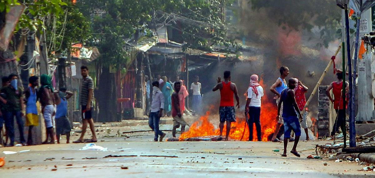  A fire set ablaze during clashes, allegedly between the BJP and TMC activists, from Kankinara under the Bhatpara Assembly constituency where by-election was underway, in North 24 Parganas, Sunday, May 19, 2019. (PTI Photo)