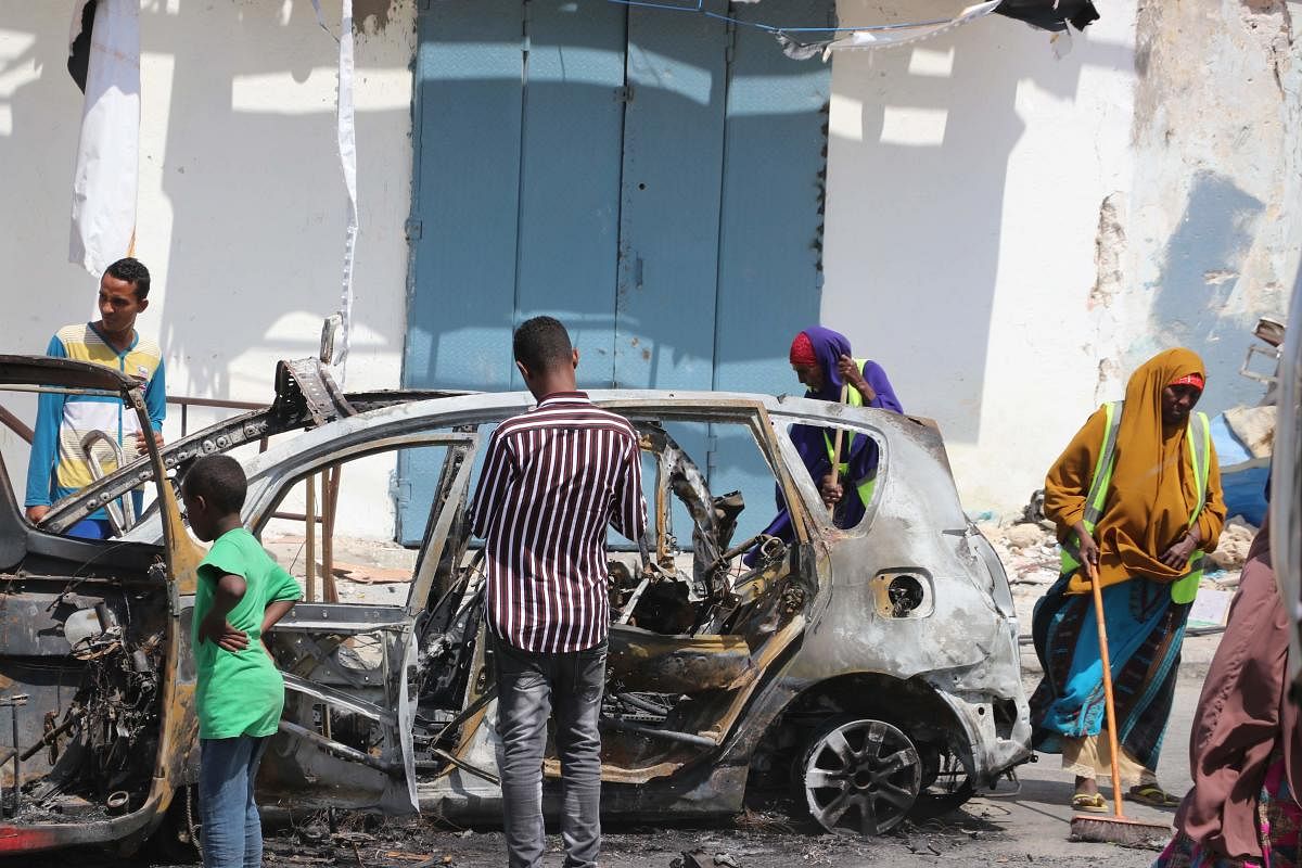 People start cleaning debris at the site where a car bomb exploded near the Somali parliament in Mogadishu, Somalia. (AFP Photo)