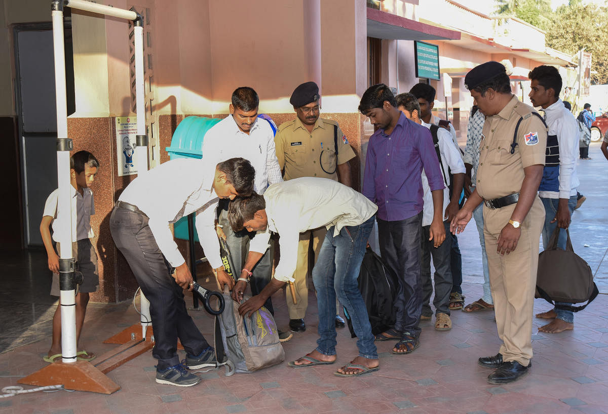 The police check backpack of a passenger at Davanagere railway station on Friday. DH Photo