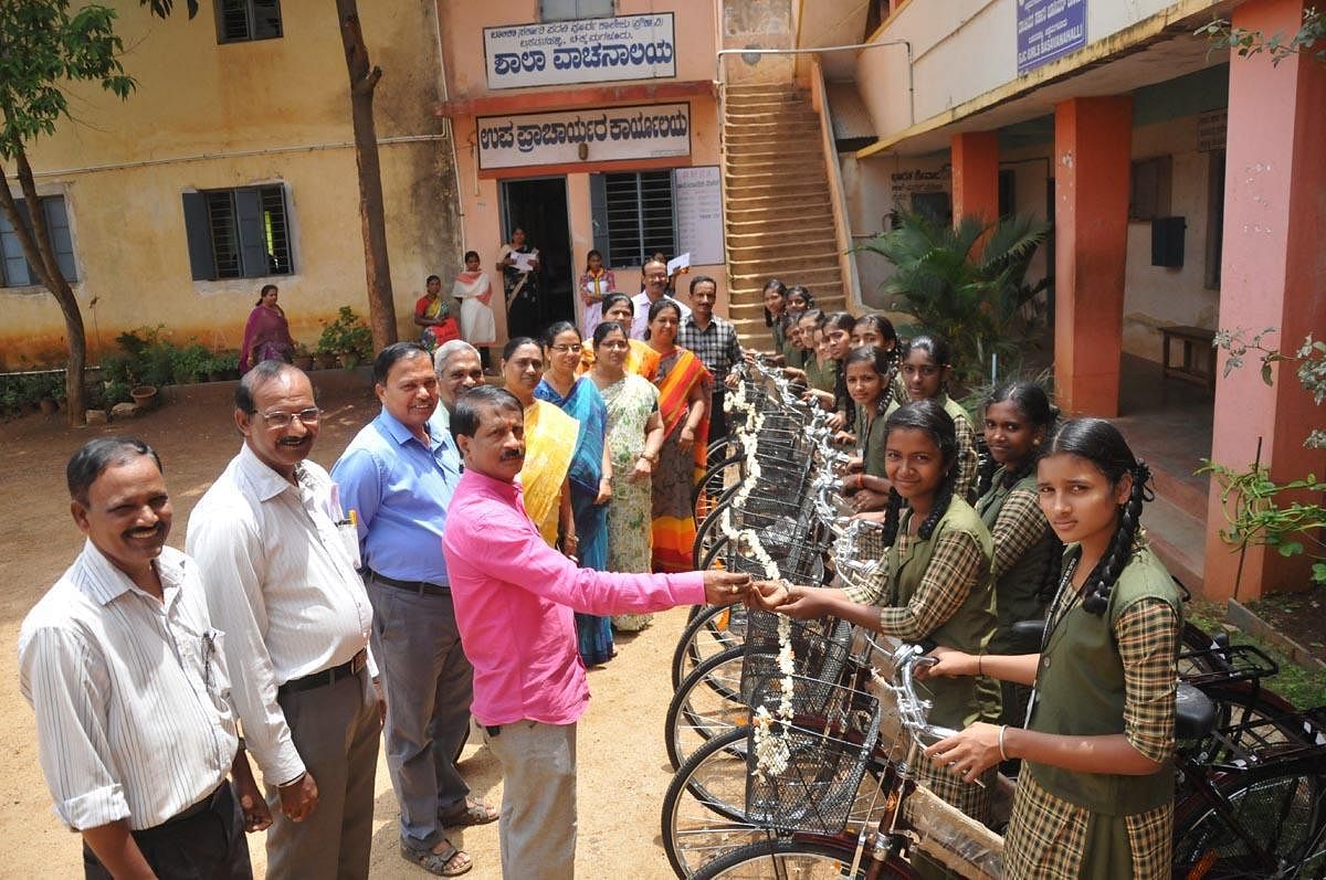 Government Girls High School Development and Monitoring Committee president Varasiddhi Venugopal distributes cycles to the students on Tuesday.