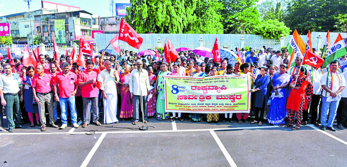 Members of trade unions stage a protest in front of Town Hall in Mangaluru on Wednesday. DH PHOTO