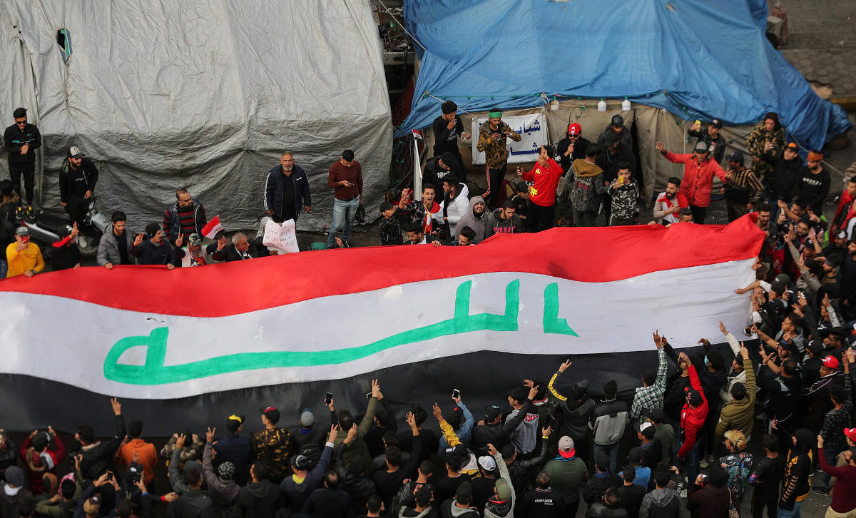 Iraqi demonstrators carry an Iraqi flag (Reuters Photo)
